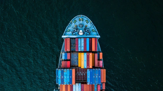 A cargo ship with shipping containers for parcel delivery from Calgary, Canada to Denmark Europe